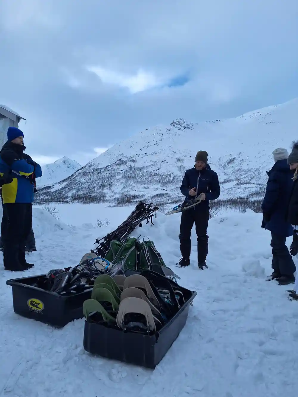 A crate of snowshoes being handed out at the trailhead