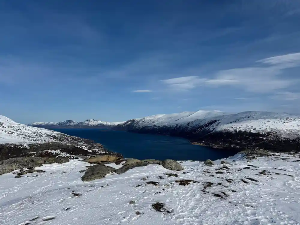 The fjord and the dark sea from a snowy shoulder