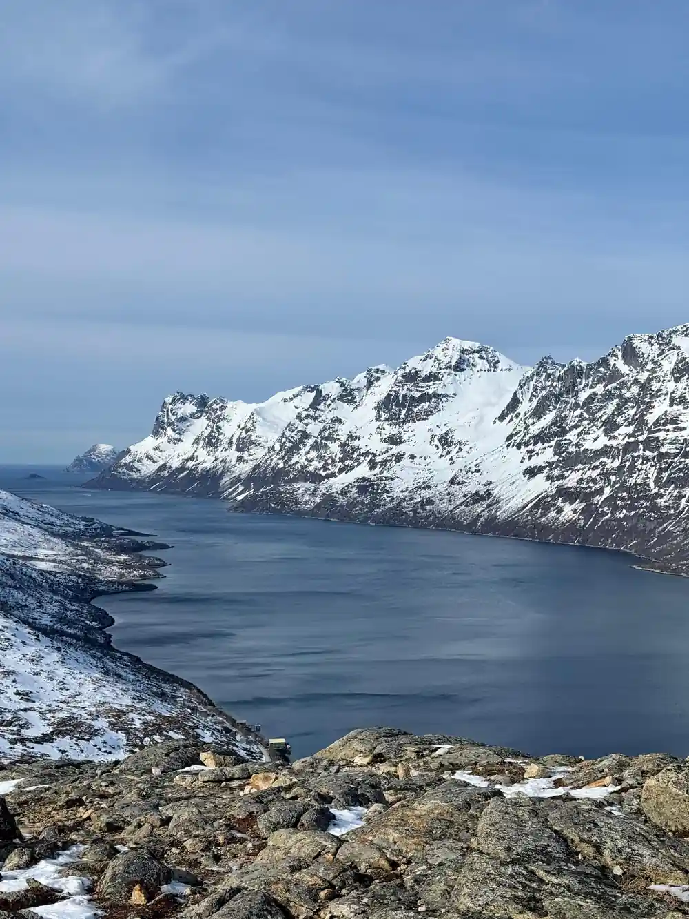 Sharp peaks above the still water of the fjord