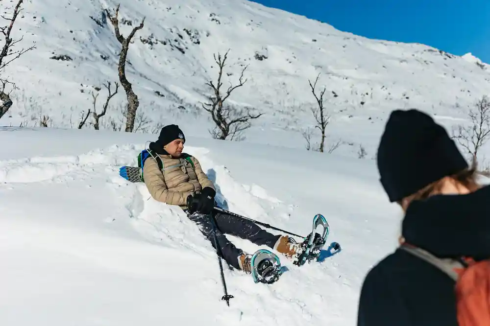 Someone resting in the snow with snowshoes on
