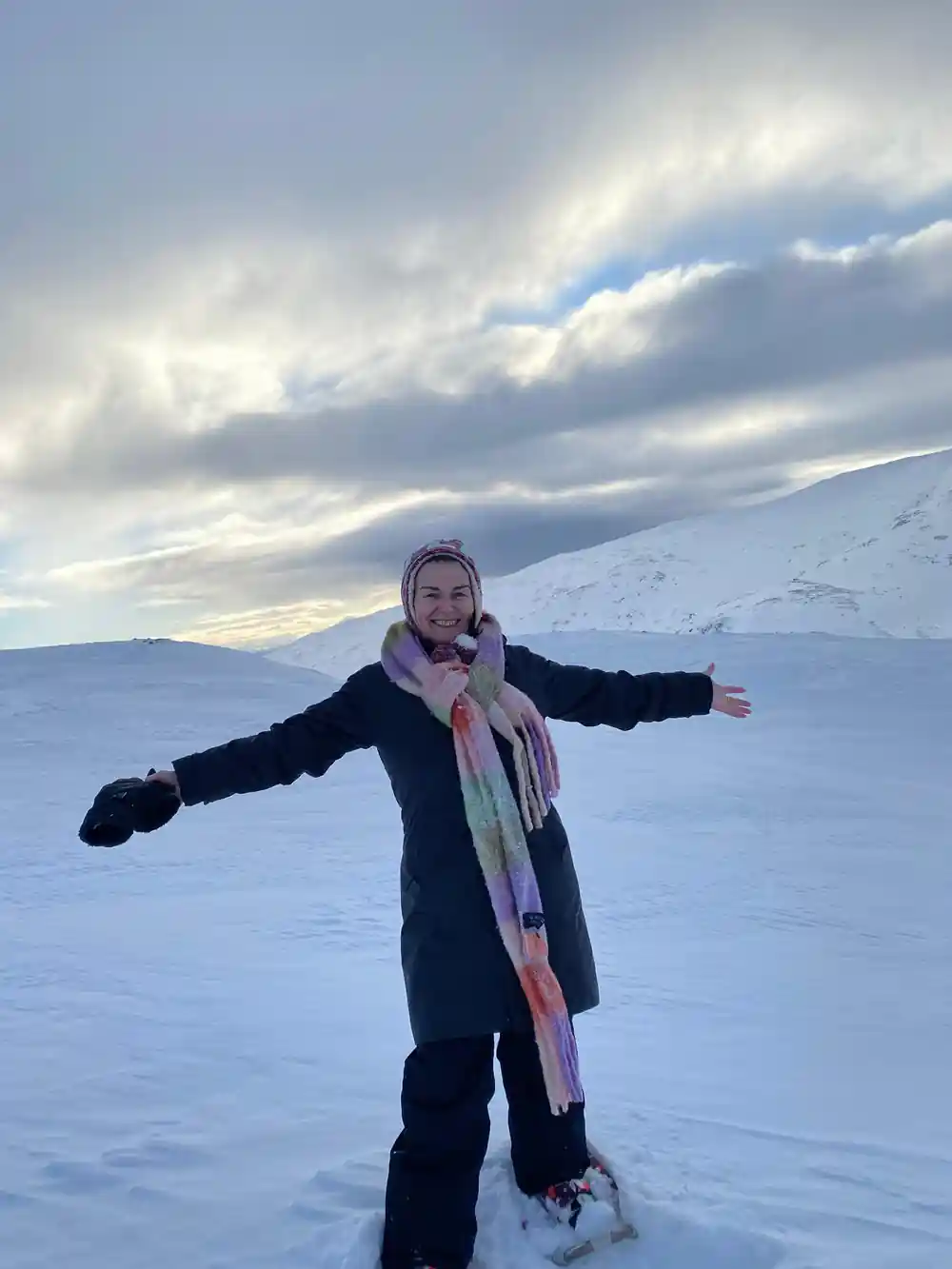 A walker with arms wide on the open snow